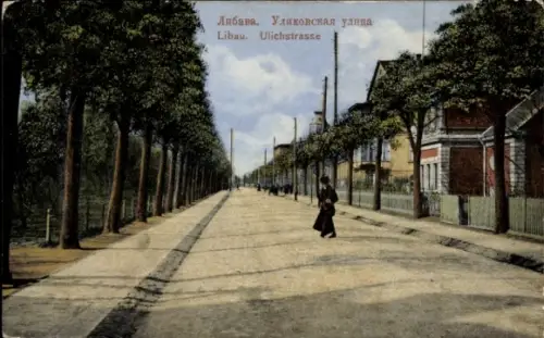 Ak Liepaja Libau Lettland, Straße mit Bäumen, Person auf dem Gehweg, Schriftzug in Russisch und D