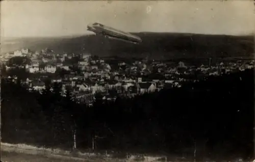 Künstler Ak Luftschiff, Zeppelin über einer Ortschaft