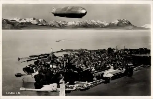 Ak Lindau am Bodensee Schwaben, Luftaufnahme von  Zeppelin, Berge im Hintergrund