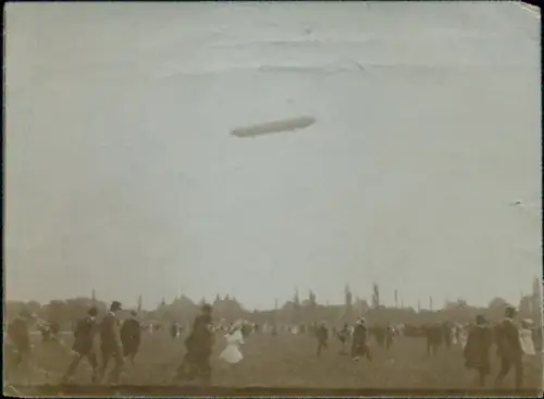 Foto Zeppelin über einer Stadt, Schaulustige auf einem Flugplatz