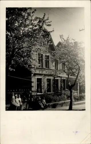Ak Blankenburg am Harz, Haus mit Bäumen, Menschen auf der Bank, Schwarz-Weiß-Foto