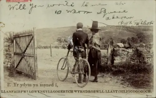 Ak Wales, Menschen in Trachten, Fahrrad, Llanfairpwllgwyngyll