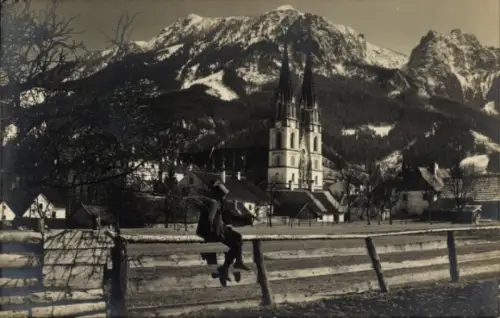 Ak Admont Steiermark, Berglandschaft, Kirche mit Türmen, Mann auf Zaun, Bäume