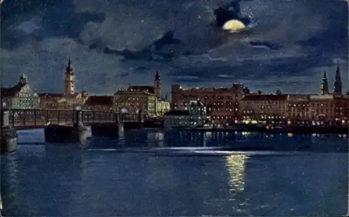 Ak Linz an der Donau Oberösterreich, Nachtansicht, beleuchtete Gebäude, Brücke, Wasseroberfläche,