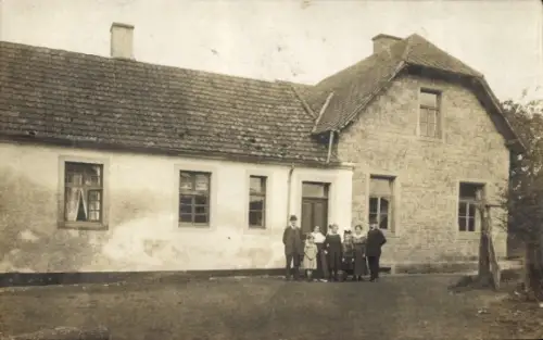 Foto Ak Heilenbach in der Eifel, Familie vor einem Wohnhaus