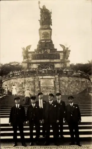 Ak Rüdesheim am Rhein, Sechs Männer in Anzügen, Denkmal im Hintergrund, Rüdesheim