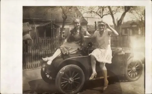 Foto Ak Zwei Frauen, auf einem Auto sitzend