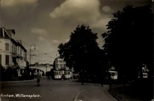 Ak Arnhem Gelderland Niederlande, Willemsplein in  Straßenbahnen, Bäume, Wolken