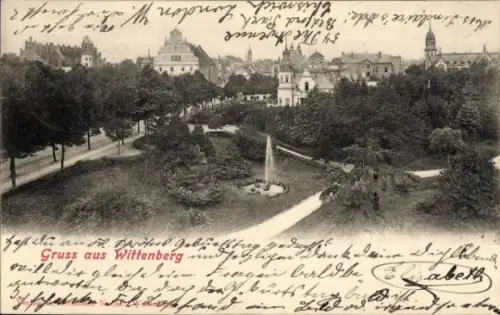 Ak Lutherstadt Wittenberg, Gruss aus  Parklandschaft, Brunnen, Gebäude im Hintergrund