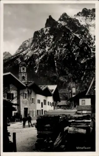 Ak Mittenwald in Oberbayern, Schneebedeckte Berge, Häuser, Uhrturm, Menschen, Mittenwald
