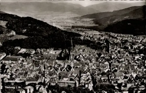 Ak Freiburg im Breisgau, Luftaufnahme von Freiburg, Stadtansicht, Berge im Hintergrund