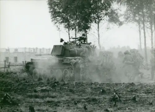 Foto Manöver der NVA, Nationale Volksarmee, DDR, Soldaten in der Deckung eines Panzers
