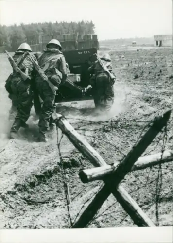 Foto Manöver der NVA, Nationale Volksarmee, DDR, Soldaten mit Geschütz, Übungsgelände, Stacheldraht