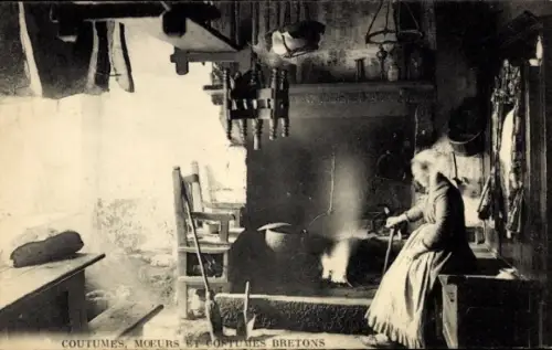 Ak Bretagne, Frau in bretonischer Tracht in der Küche