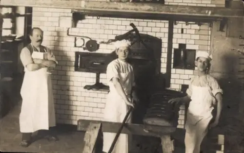 Foto Ak drei Bäcker in einer Backstube, Ofen