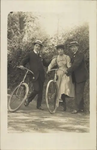 Foto Ak Frau und Männer mit Fahrrädern, Portrait