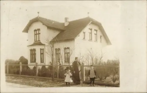 Foto Ak Kellinghusen in Holstein, Wohnhaus, Frau mit zwei Kindern vor dem Gartenzaun, Fam. Glissmann
