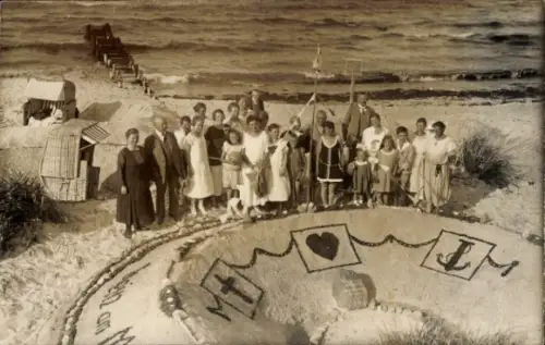 Foto Ak Badegäste am Strand, Gruppenbild neben einer Sandburg