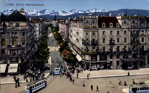 Ak Zürich Stadt Schweiz, Breite Straße mit Straßenbahnen, Eckhäusern mit Ladenschildern, Fußgänge