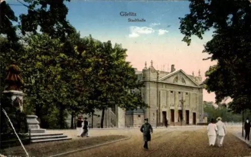 Ak Görlitz in der Lausitz, Stadthalle, Bäume, Denkmal links, Passanten in r Kleidung