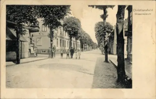 Ak Christiansfeld Kolding Dänemark, Schmale Straße, Bäume beidseitig, einige Personen, histori...