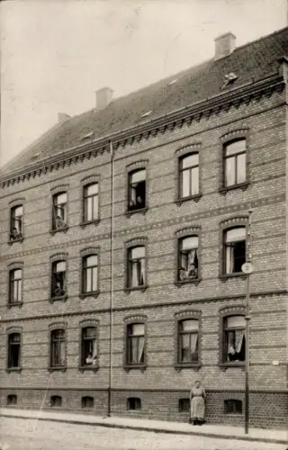 Ak Schkeuditz in Sachsen, Backsteinhaus, Bewohner an Fenstern