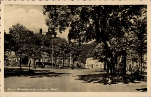 Ak Oberwiesenthal im Erzgebirge, Marktplatz mit Bäumen, Uhrturm an Haus, Denkmal/Brunnen, Ladenze