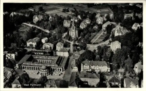 Ak Bad Pyrmont in Niedersachsen, Luftaufnahme von  Gebäude, Bäume, Straßen