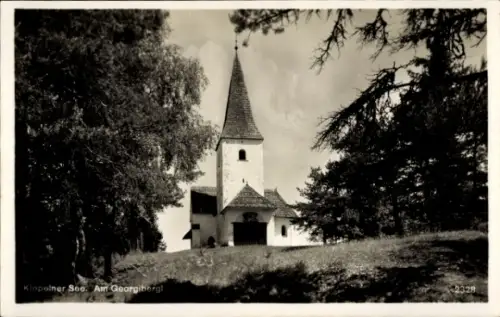 Ak Sankt Kanzian am Klopeiner See Kärnten, Kirche mit spitzem Turm, Eingangsportal, Wiese im Vord