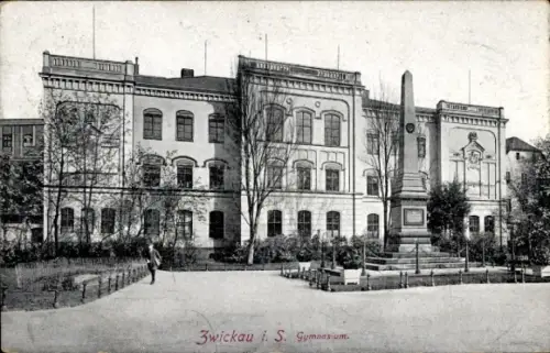 Ak Zwickau in Sachsen, Schulgebäude (Gymnasium) mit Obelisk-Denkmal, Bäume und Gehweg, einzelne P