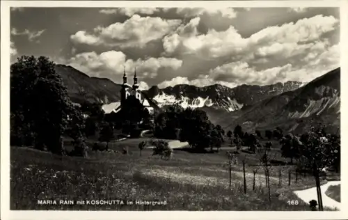 Ak Maria Rain in Kärnten, Kirche mit zwei Türmen auf Hügel, Bergkette mit Schneefeldern, Wiese mi