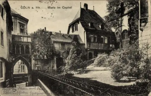 Ak Cöln Köln am Rhein, Torbogen, enge Gasse, schmiedeeiserner Zaun, mehrstöckige Wohnhäuser, Büsc