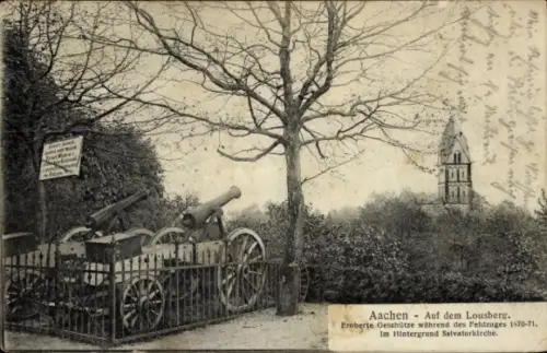 Ak Aachen, Eroberte Geschütze auf Lafetten, umzäunter Kanonenstand, kahler Baum, Kirchturm