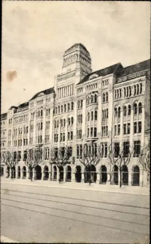 Ak Leipzig, Mehrstöckige Fassadenfront mit zentralem Turm, Arkaden im Erdgeschoss, gepflanzte Bäu