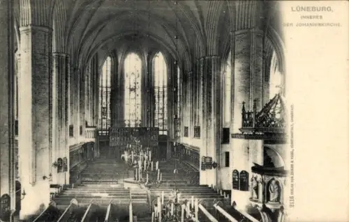 Ak Lüneburg in Niedersachsen, gotischer Kircheninnenraum, hohe Spitzfenster/Chor, Reihen von Bänk