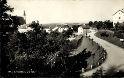 Ak Bad Kreuzen in Oberösterreich, Kirchturm, Wohnhäuser, geschwungene Landstraße mit Leitpfosten,