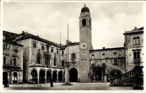 Ak Dubrovnik Kroatien, Glockenturm mit Uhr, Arkaden links, offener Platz mit Flaggenmast, Treppe 