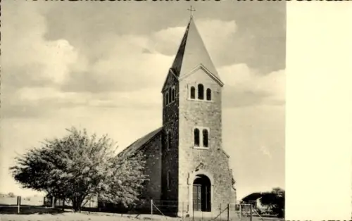 Ak Keetmanshoop Namibia, Evangelische Kirche mit Glockenturm, Eingangsportal, Baum, Zaun, wolkige
