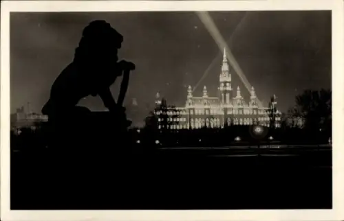 Ak Wien 1 Innere Stadt, Löwenstatue-Silhouette im Vordergrund, beleuchtetes Rathaus mit Turm, kre