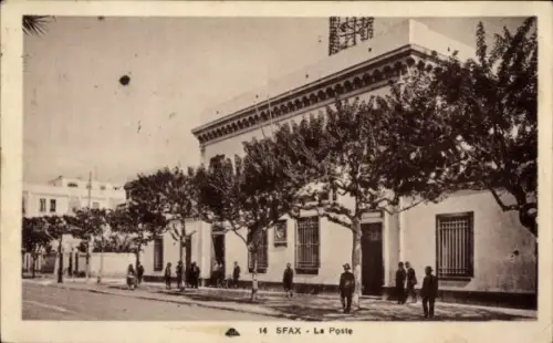Ak Sfax Tunesien, Postamt-Fassade, gestutzte Bäume, Passanten am Gehweg, Straßenseite