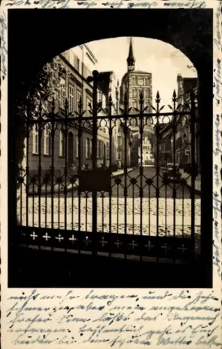 Ak Stralsund in Vorpommern,  Blick durch Tor, Rathaus mit Turm, Kopfsteinpflaster, schmiedeeisern