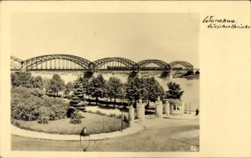Ak Warszawa Warschau Polen, Stahlbogenbrücke über Fluss, Uferpark mit Wegen und Torpfeilern, Stra