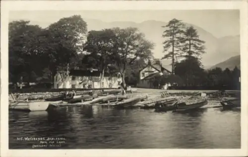 Ak Ambleside Lake District Cumbria England, Wasserlandschaft, Boote am Ufer, Bäume, Berge im Hint