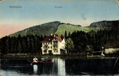 Ak Mariazell Steiermark, Haus am Seeufer, Ruderboot mit Personen, Wasserreflexion, bewaldete Hüge