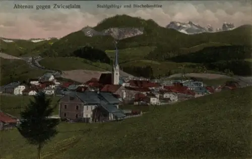 Ak Abtenau in Salzburg, Kirche mit hohem Turm, Häuser mit roten Dächern, grüne Wiesen, Hügel, Ber