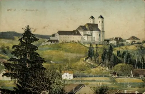 Ak Weiz Steiermark , Gebäude mit zwei Türmen auf Hügel, Nadelbaum im Vordergrund, Häuser und Feld