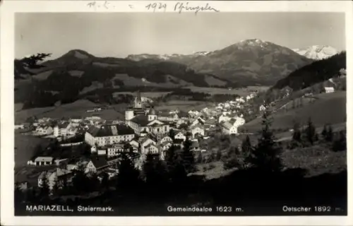 Ak Mariazell Steiermark, Panorama,Kirchturm,Reihen Häuser,Vordergrund Nadelwald,Berge 1623/1892m