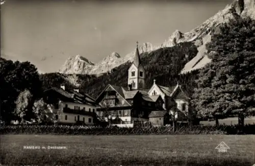 Ak Ramsau am Dachstein Steiermark, Kirchturm, mehrere Häuser, markante Berggipfel, Wiese im Vorde
