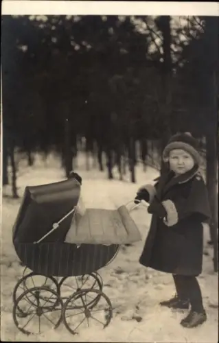 Foto Ak Mädchen mit einem Kinderwagen, Winter
