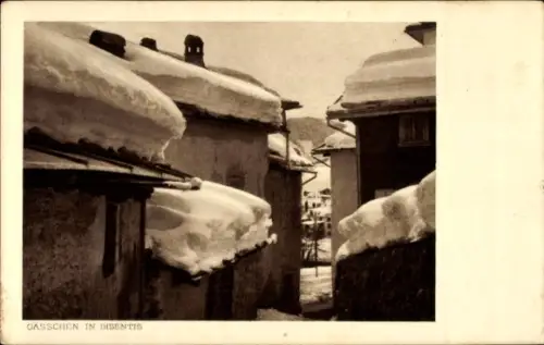 Ak Disentis Kt. Graubünden, Schneebedeckte Dächer, enge Gassen, winterliche Landschaft